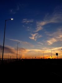 Silhouette street against sky during sunset