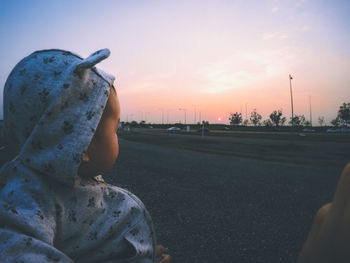 Close-up of hand against sky during sunset