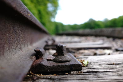 Close-up of rusty metal chain on railroad track