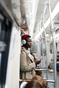 Full length of young man sitting in train