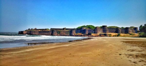 Scenic view of beach against clear blue sky