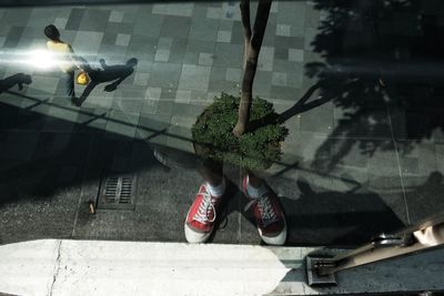 Low section of woman standing on sidewalk