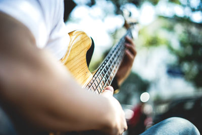 Midsection of man playing guitar