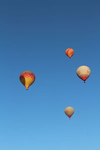 Low angle view of hot air balloon against clear blue sky