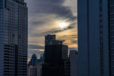 Modern buildings in city against cloudy sky