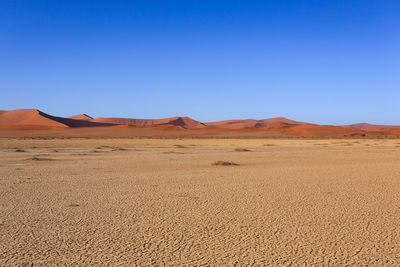 Scenic view of desert against clear blue sky