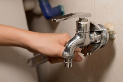 Close-up of hand holding faucet