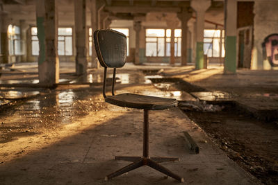 Empty chairs and table in abandoned building