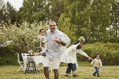 Full length of father with daughter standing against trees