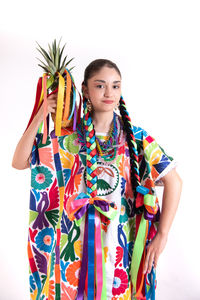 Young woman standing against multi colored background