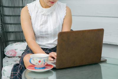 Midsection of woman with coffee cup