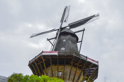 Low angle view of traditional windmill against sky