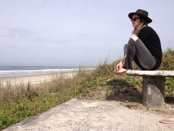 Full length side view of woman wearing sunglasses against sky