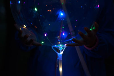 Close-up of hand holding illuminated lighting equipment at night