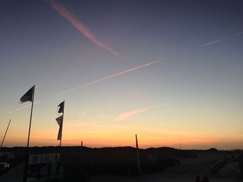 Flags waving against sky at sunset