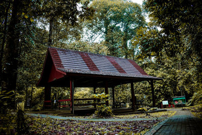 Gazebo in park by building against sky