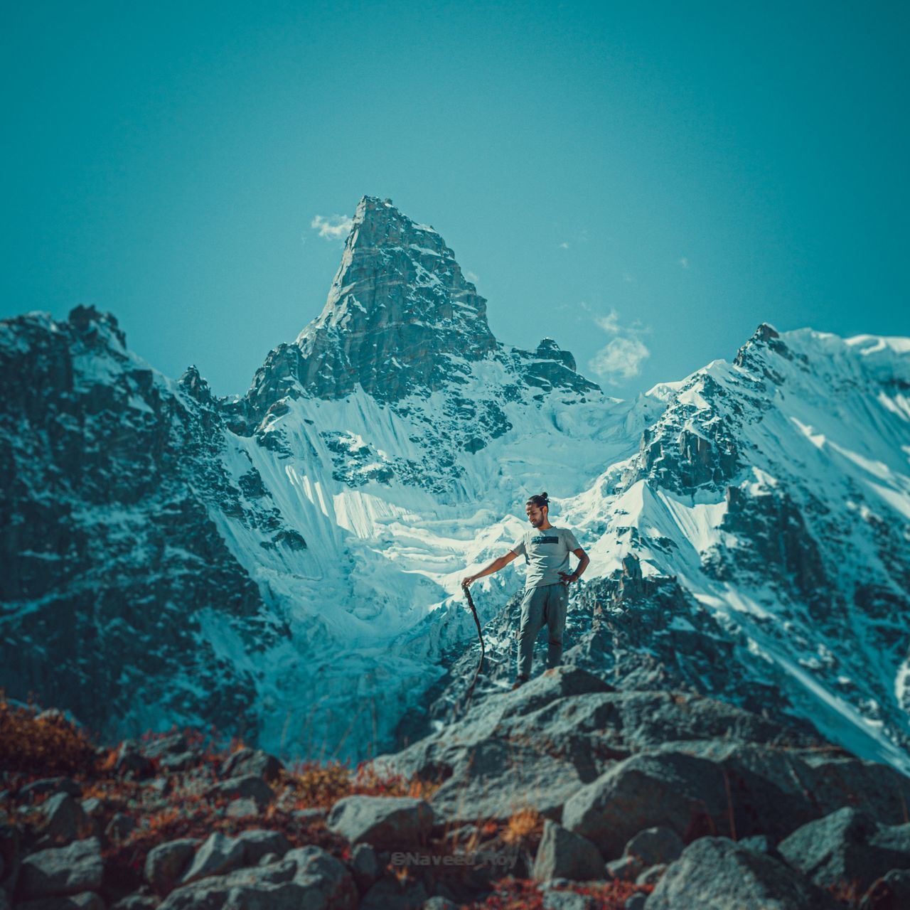 mountain, one person, adventure, snow, beauty in nature, scenics - nature, winter, leisure activity, rock, real people, nature, full length, solid, exploration, hiking, standing, cold temperature, activity, rock - object, outdoors, snowcapped mountain, formation