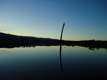 Scenic view of lake against clear blue sky