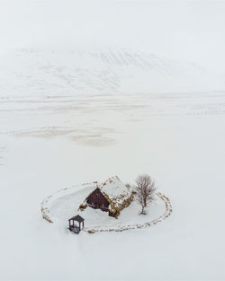 High angle view of snow covered land by sea