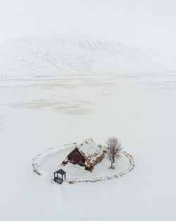 High angle view of snow covered land and turf church