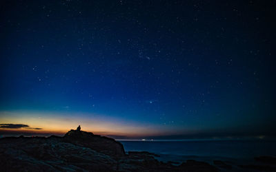 Scenic view of sea against star field at night