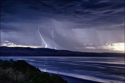 Scenic view of sea against storm clouds