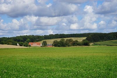 Scenic view of green landscape against cloudy sky