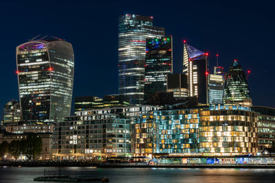 Illuminated buildings in city against sky at night