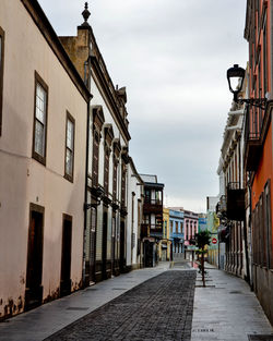 People walking on footpath amidst buildings in city