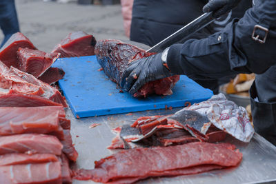 Hand holding fish at market stall