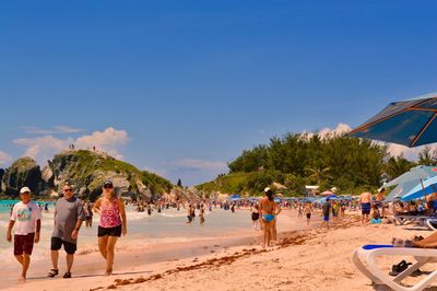 People at beach against blue sky