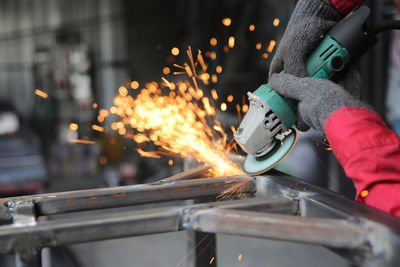 Cropped hand of man welding metal