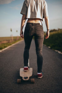 Low section of woman standing on skateboard