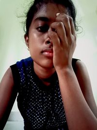 Close-up portrait of beautiful young woman against wall at home