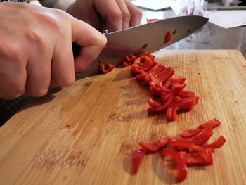 Midsection of person preparing food on cutting board