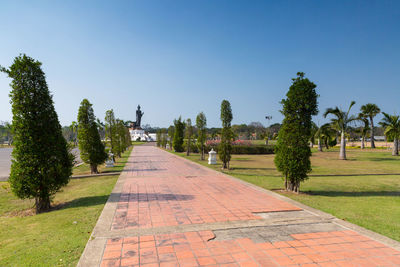 Footpath in park against clear sky