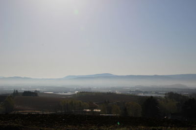 Scenic view of landscape against sky during foggy weather