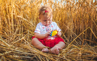 Portrait of cute girl sitting on hay