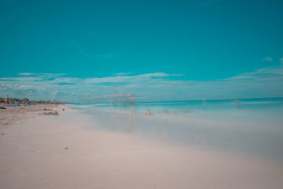 Scenic view of beach against blue sky