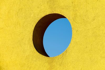 Low angle view of blue sky seen through hole