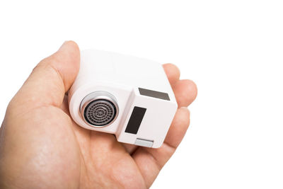 Close-up of hand holding camera over white background