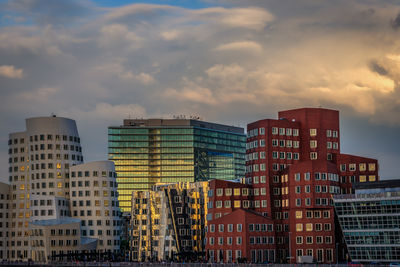 Buildings in city against sky during sunset