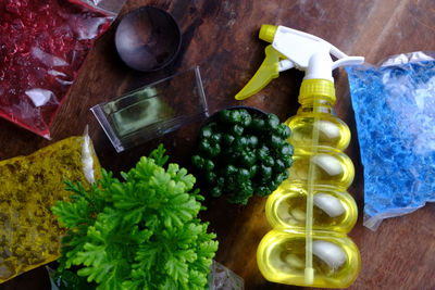 Directly above shot of crystal soil packages with potted plant and cleaning product on table