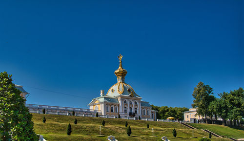 Temple against building against clear blue sky