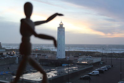 Man standing by sea against sky during sunset