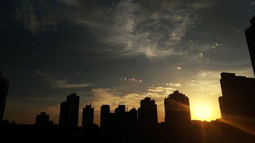 Silhouette buildings against sky during sunset