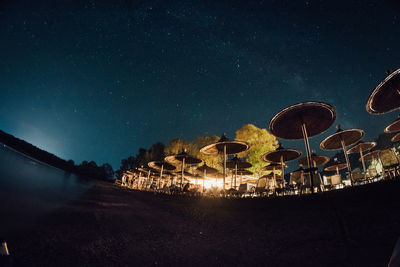 Low angle fish-eye lens shot of parasols against sky at night