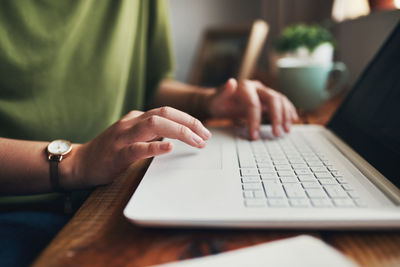 Midsection of woman using laptop on table