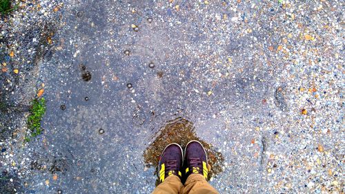 Low section of man standing by water