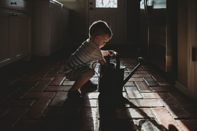 Boy looking through window at home